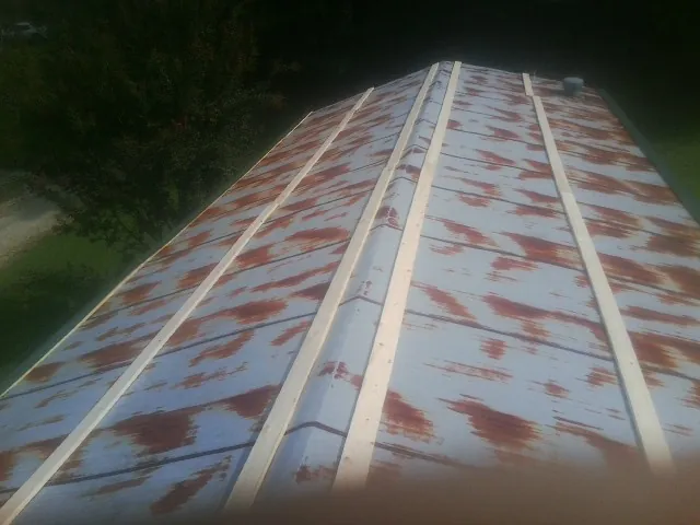 Rusted metal roof panels with new wood purlins before replacement — Storm Damage Roof Repair in Fontana by Roofing Brothers