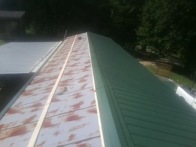Old rusted panels beside newly installed green metal roofing — Wind Damage Roof Repair by Roofing Brothers in Fontana